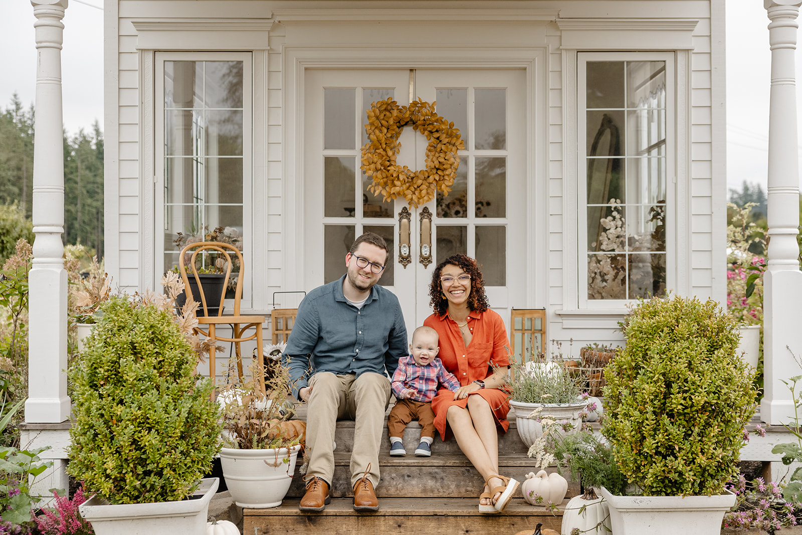 fall family photos near seattle, Washington, family sitting on porch of house together wearing orange and blue attire