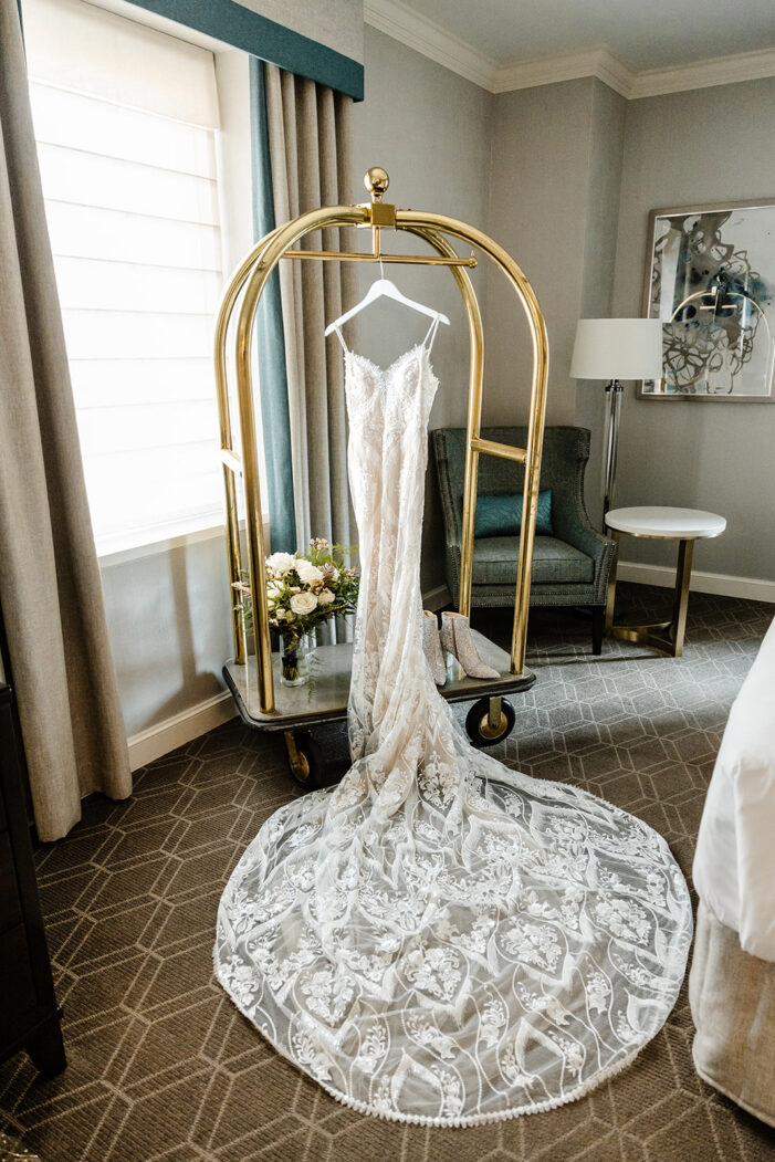 romantic wedding dress hanging on luggage car