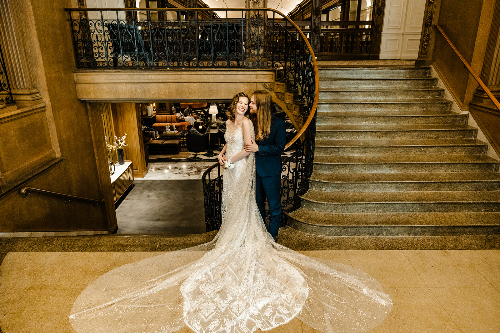 bride and groom snuggle at the bottom of stairs at Fairmont Hotel