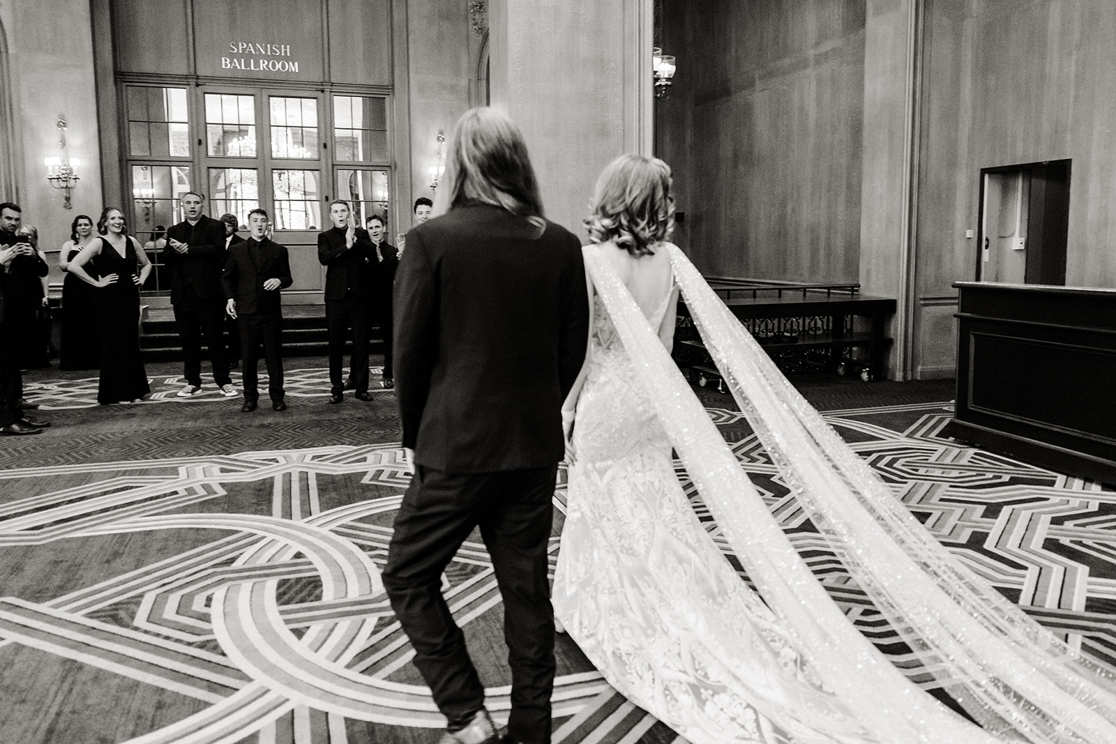 bride and groom walk across lobby at Fairmont hotel