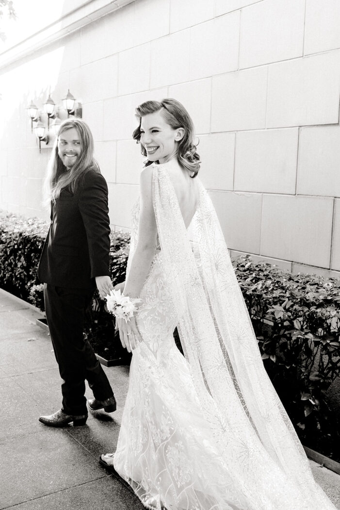 bride and groom walk together holding hands