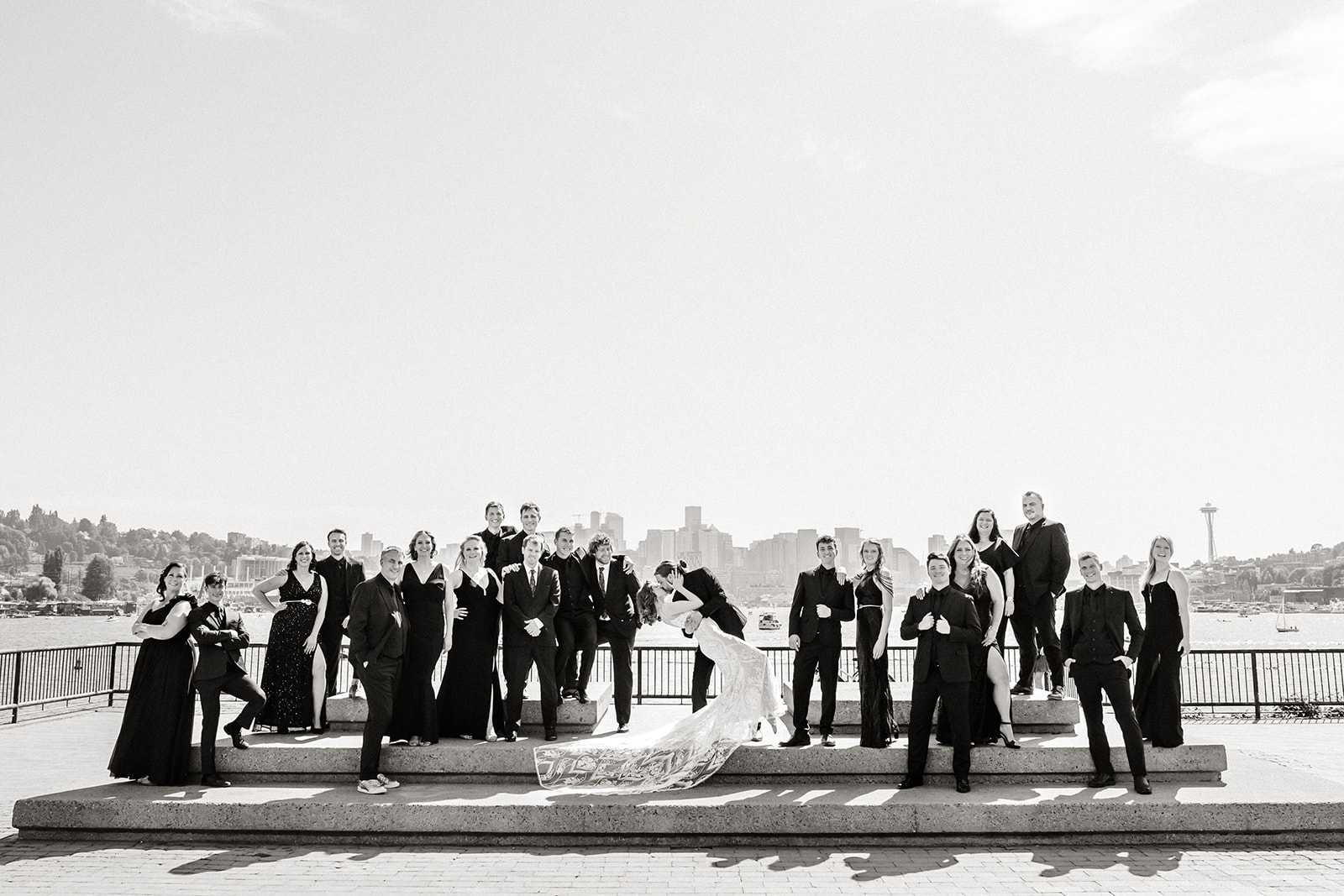 bridal party poses on steps with Seattle in background