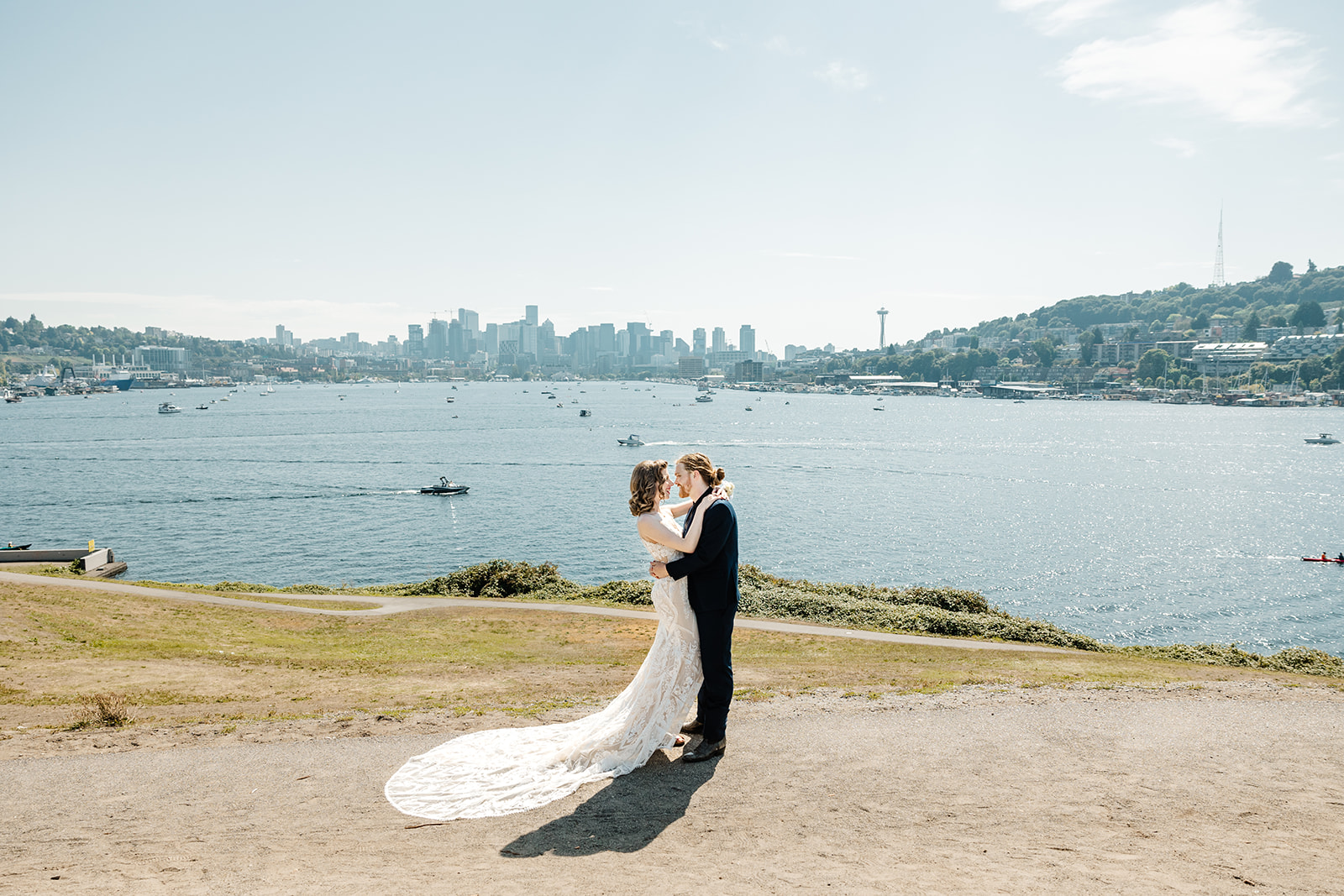 bride and groom kiss in front of seattle skyline