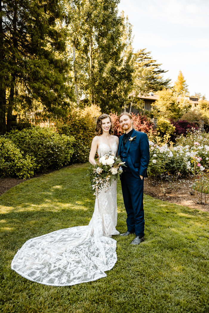 bride and groom pose in rose garden