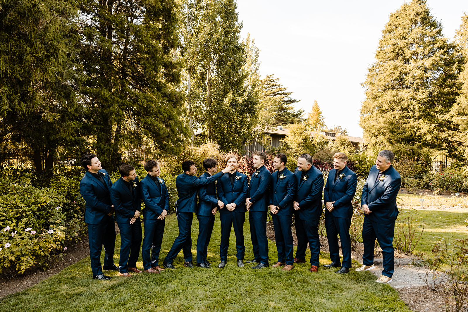 groom is jostled by groomsmen in blue suits