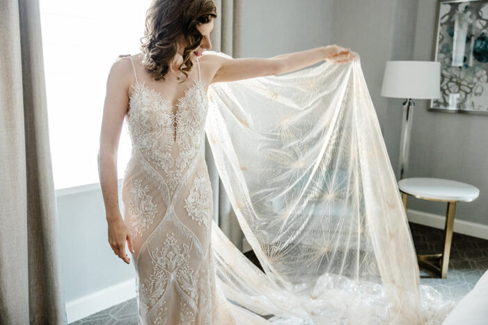 bride holds out veil