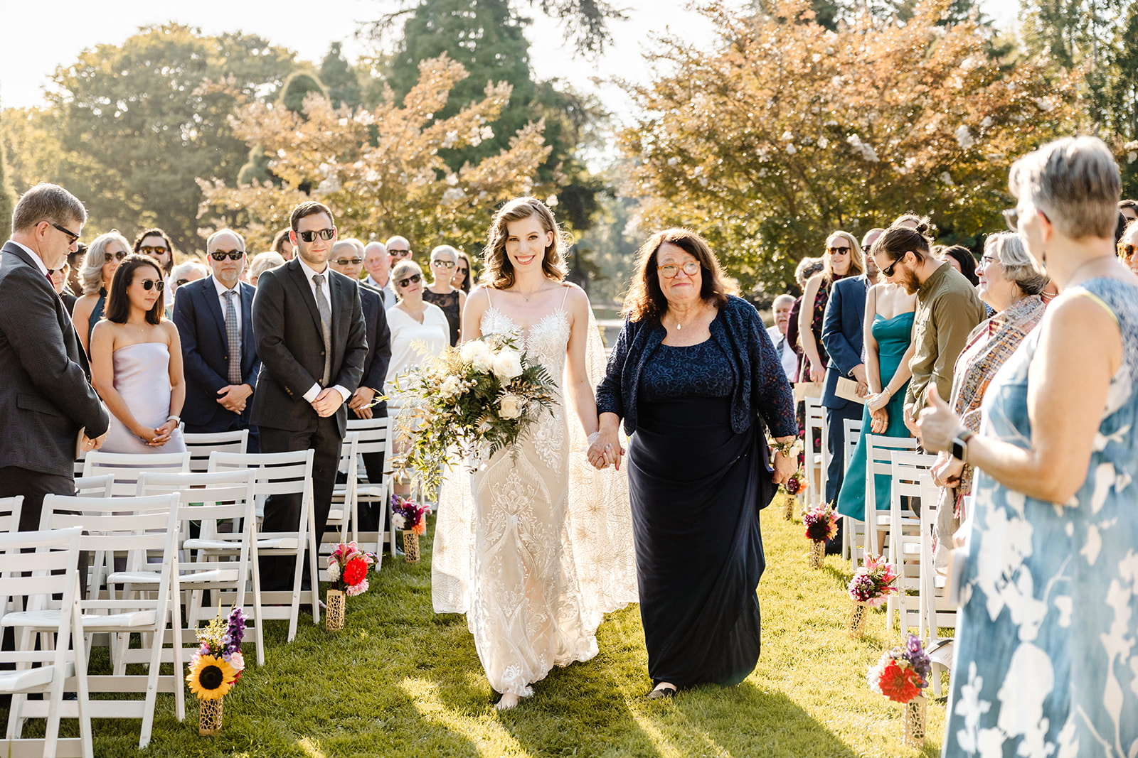 bride walks down aisle holding mothers hand