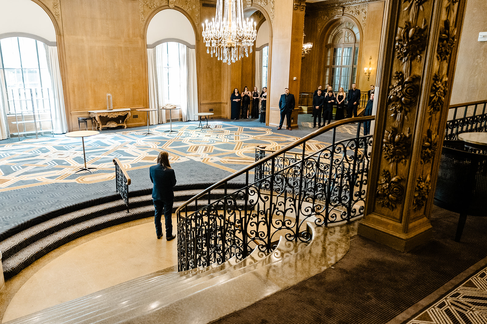 man stands at the bottom of staircase at Fairmont hotel