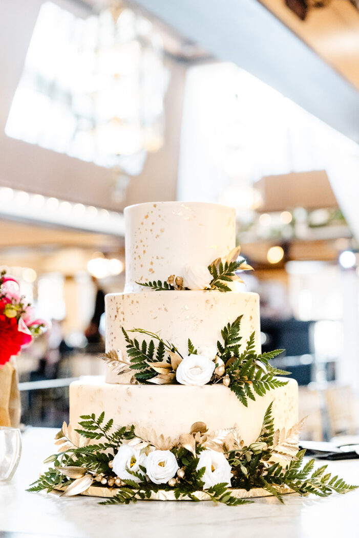 white cake with greenery and white flowers