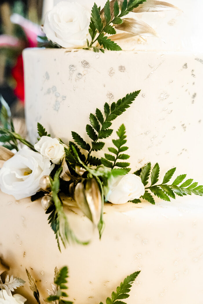 close on white cake with greenery and white flowers