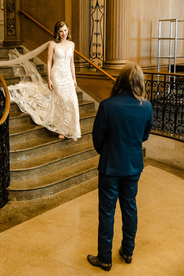 bride and groom face each other on Fairmont stairs