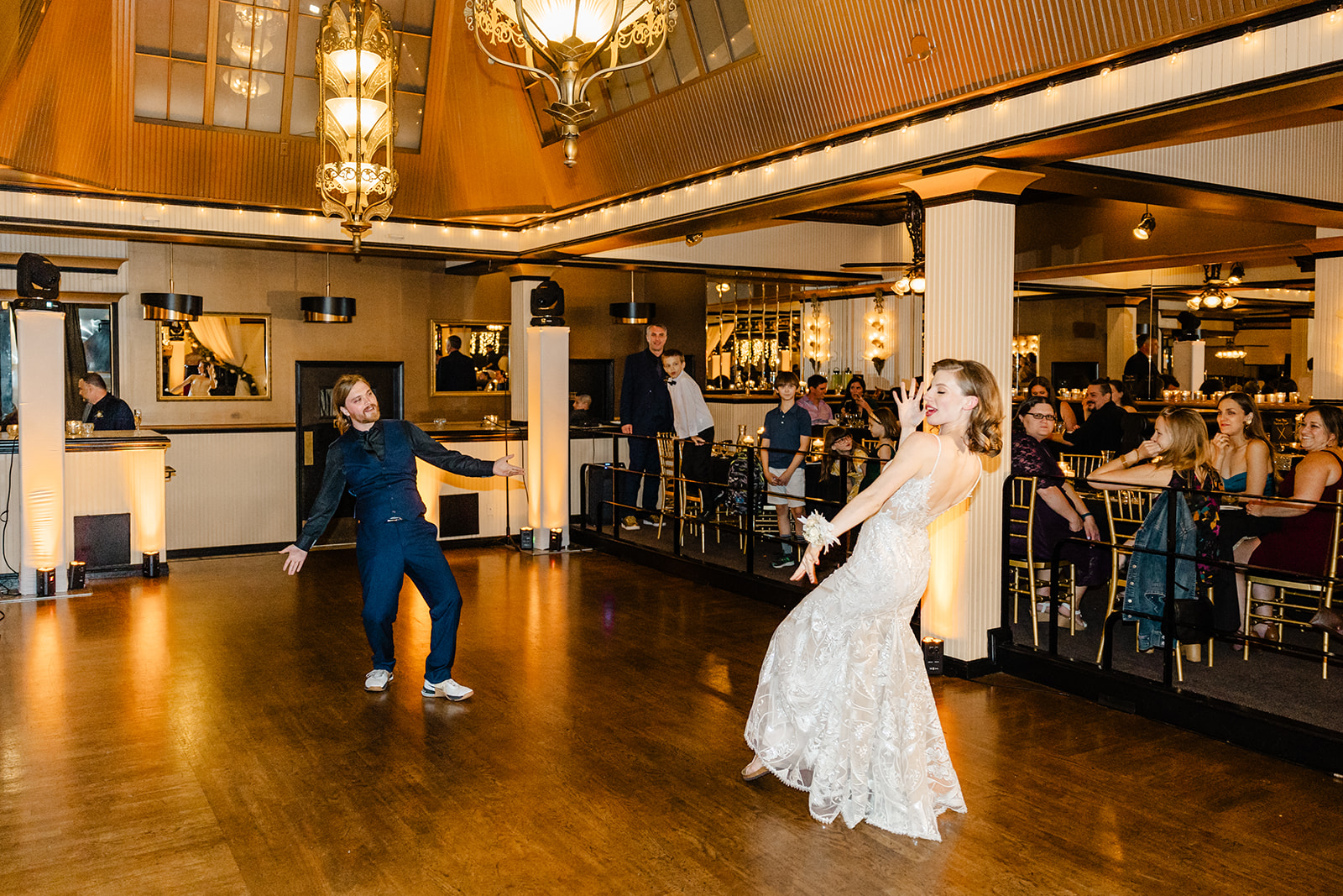 bride and groom dance while surrounded by guests