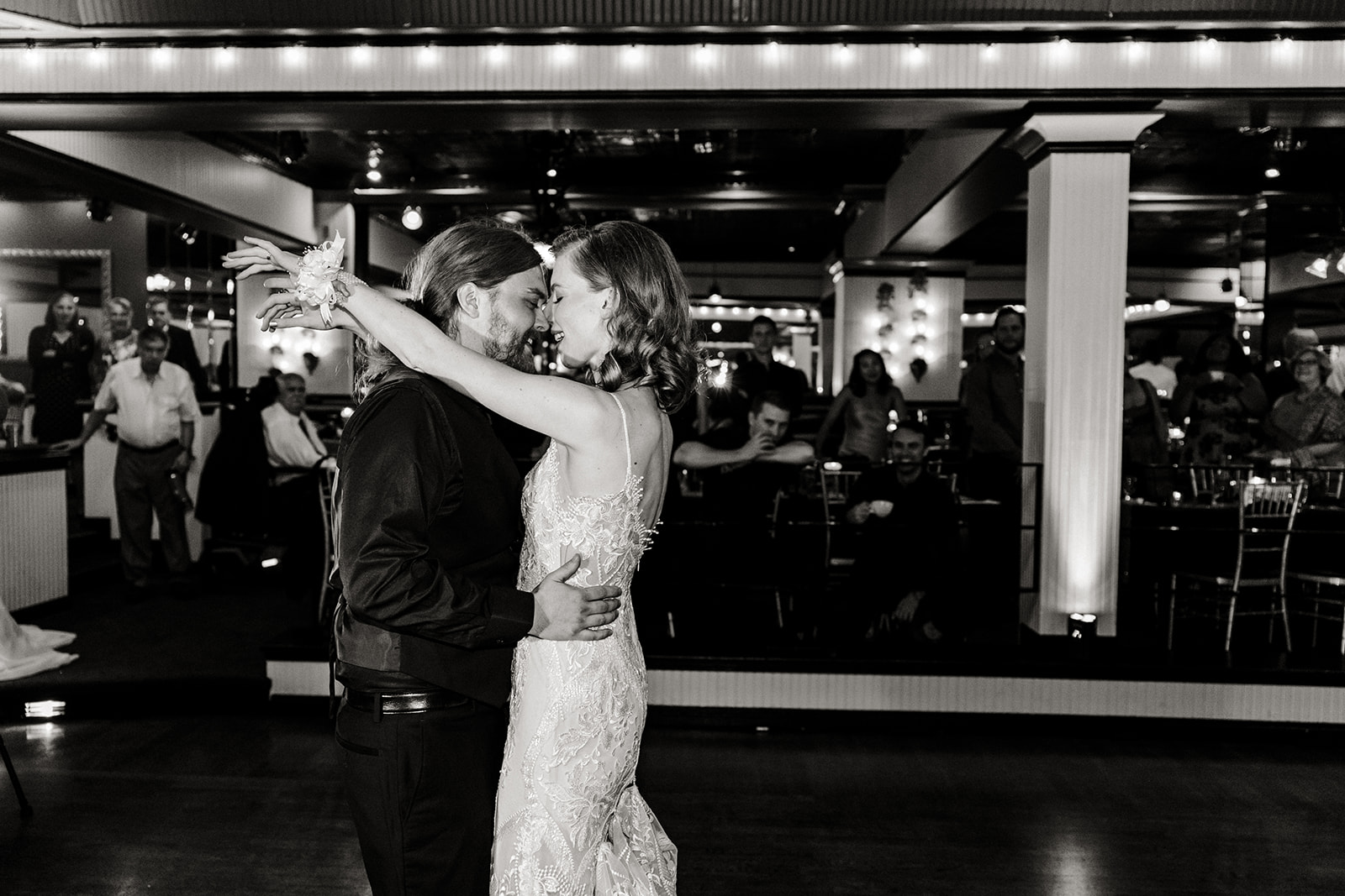 bride and groom dance surrounded by guests