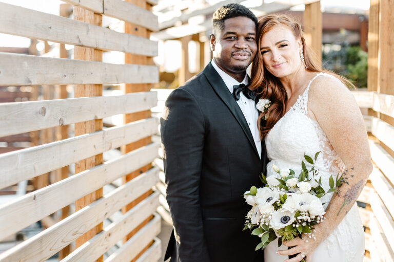 bride and groom stand with their heads together softly smiling