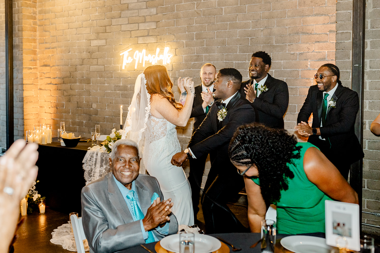 bride dances with groom and groomsman at wedding reception