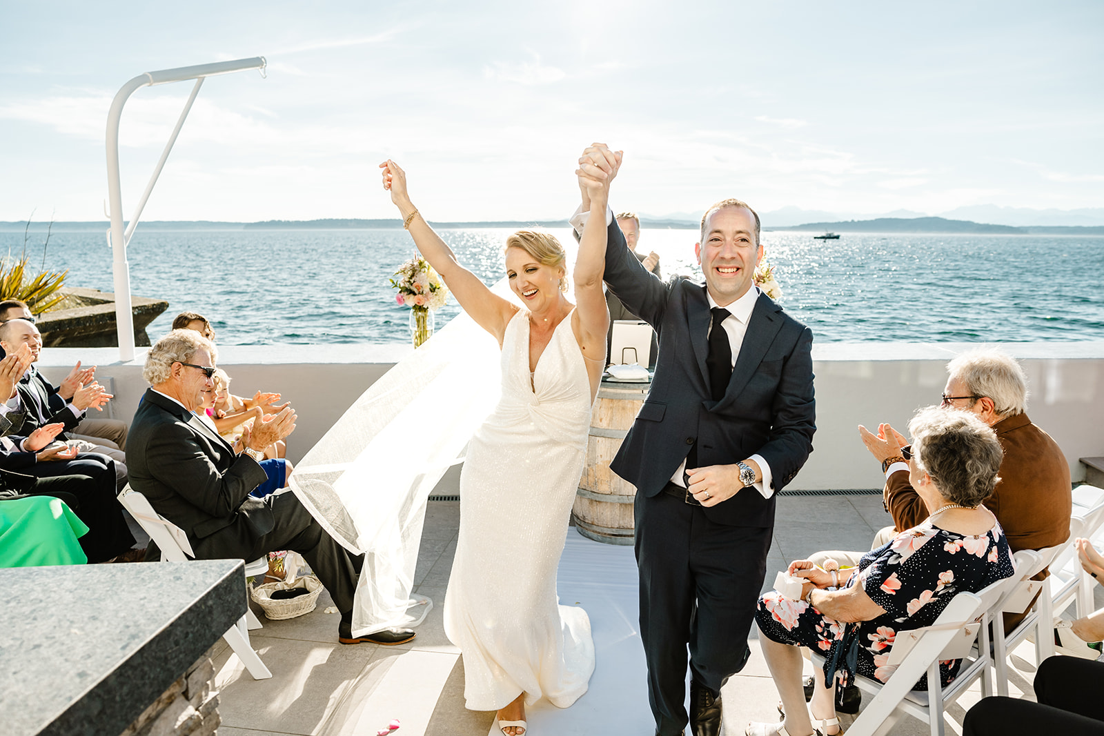 bride and groom walk up aisle smiling and cheering