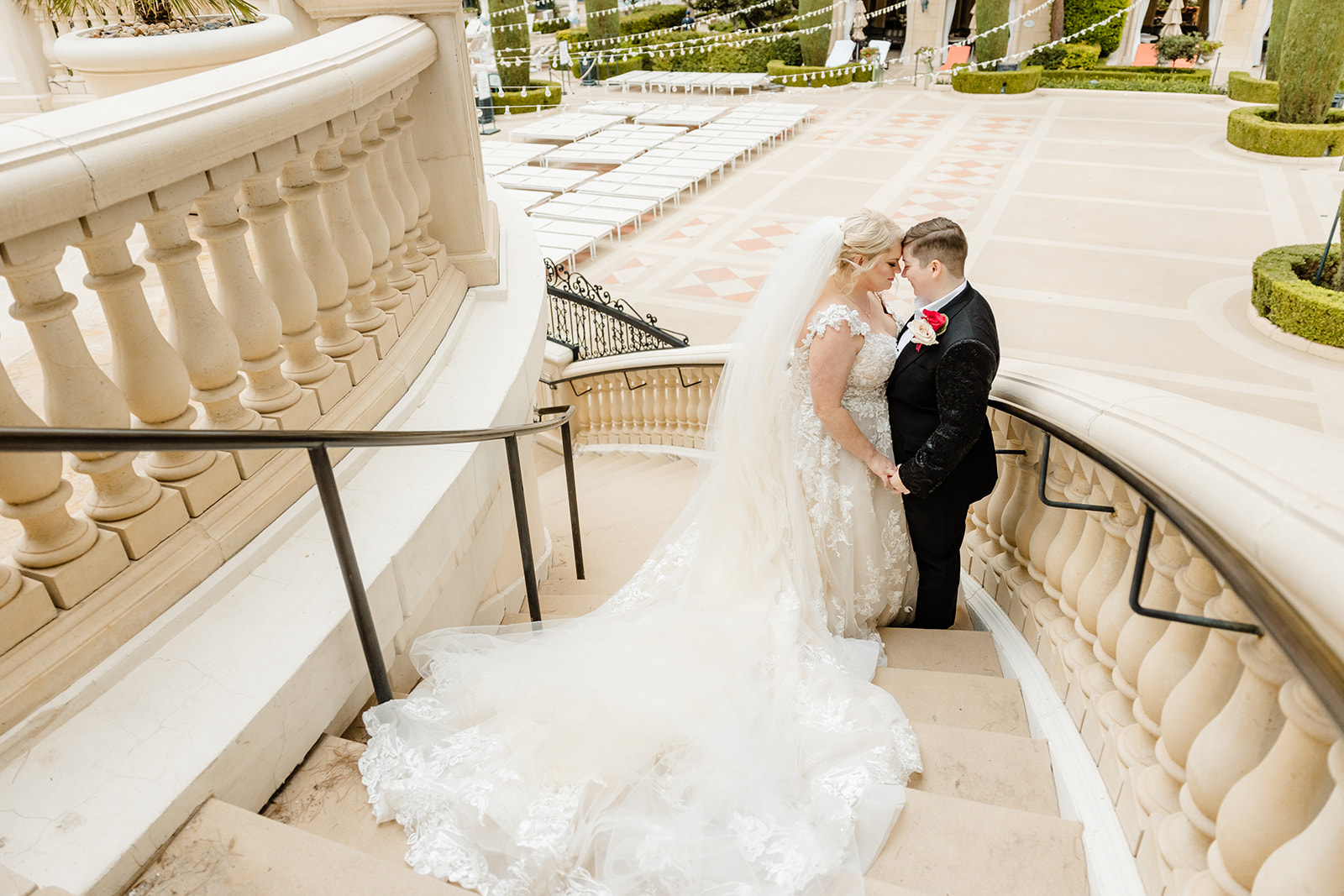 two brides stand on stairs facing each other