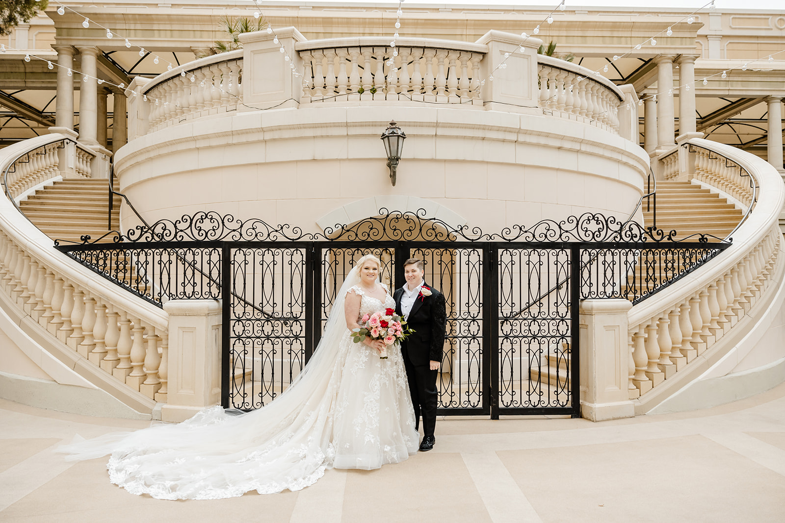 two brides stand in front of gate