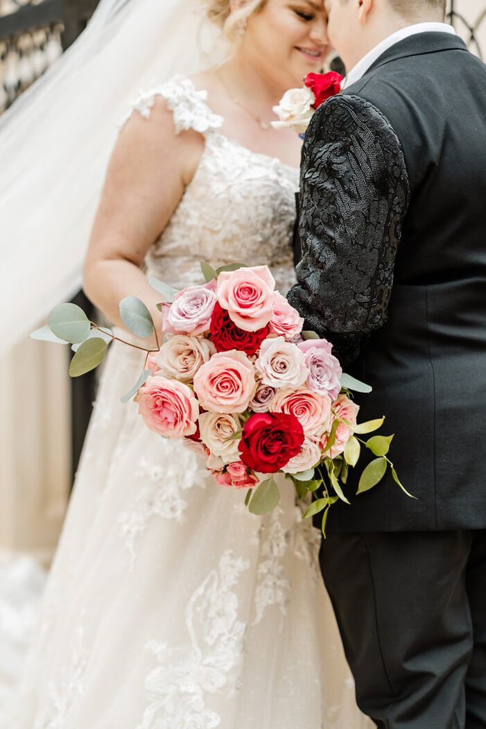 close on bride holding pink and red floral bouquet