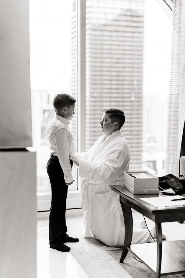 bride helps young man into suit