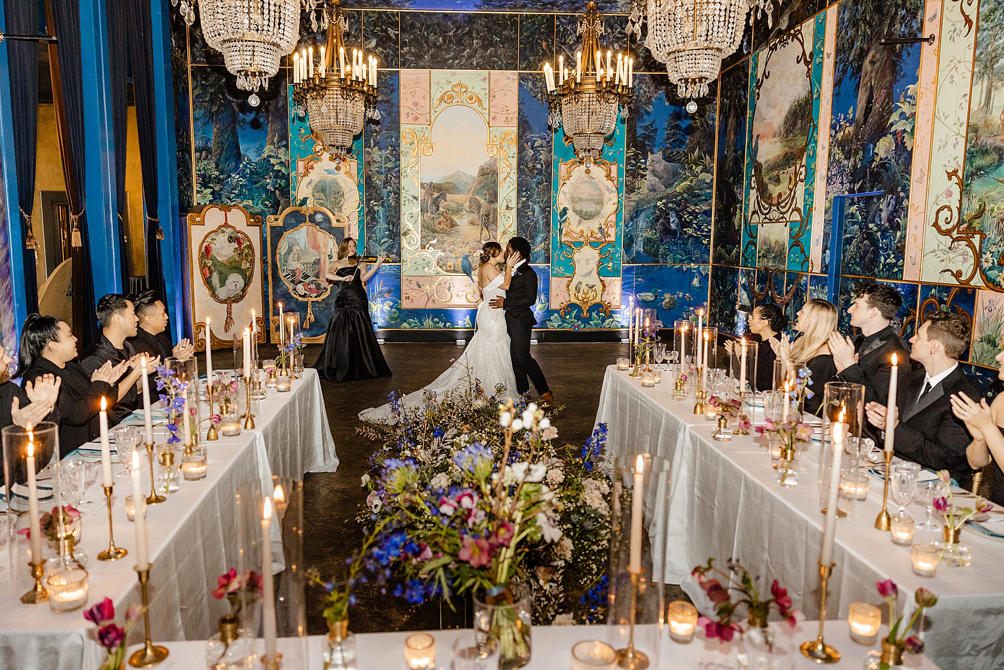 the ruins seattle wedding photographer couple grand entrance with everyone celebrating at U shape table and flower meadow in the middle