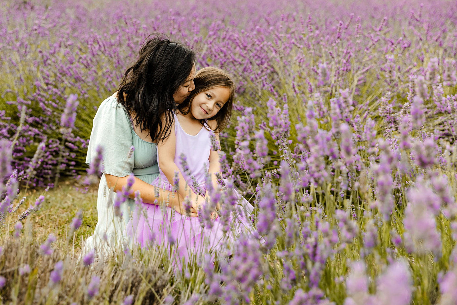 mommy and me session in flower field lavender, mom kissing daughters cheek