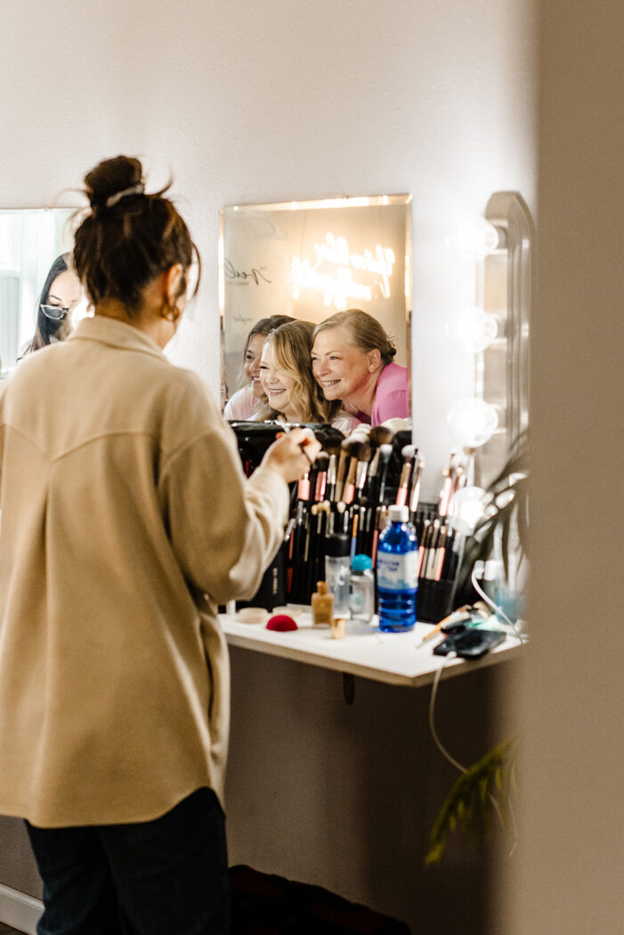 bride and bridemaids look into mirror