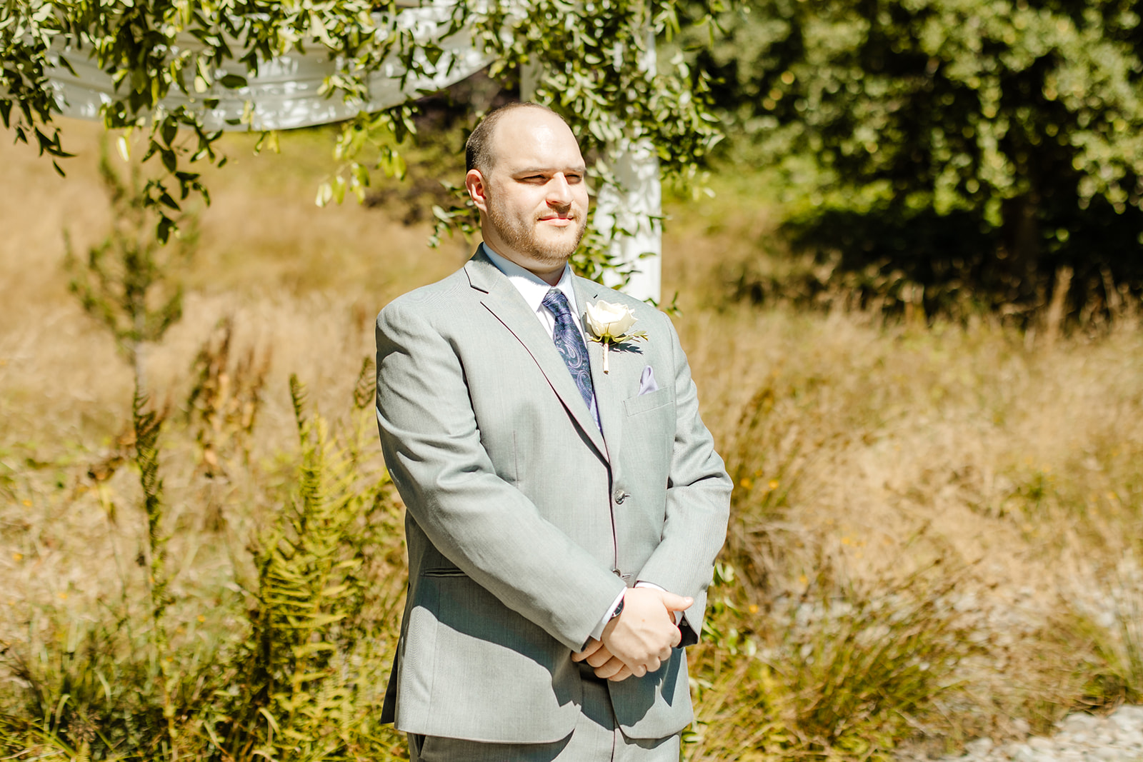 Groom waits at end of aisle during ceremony
