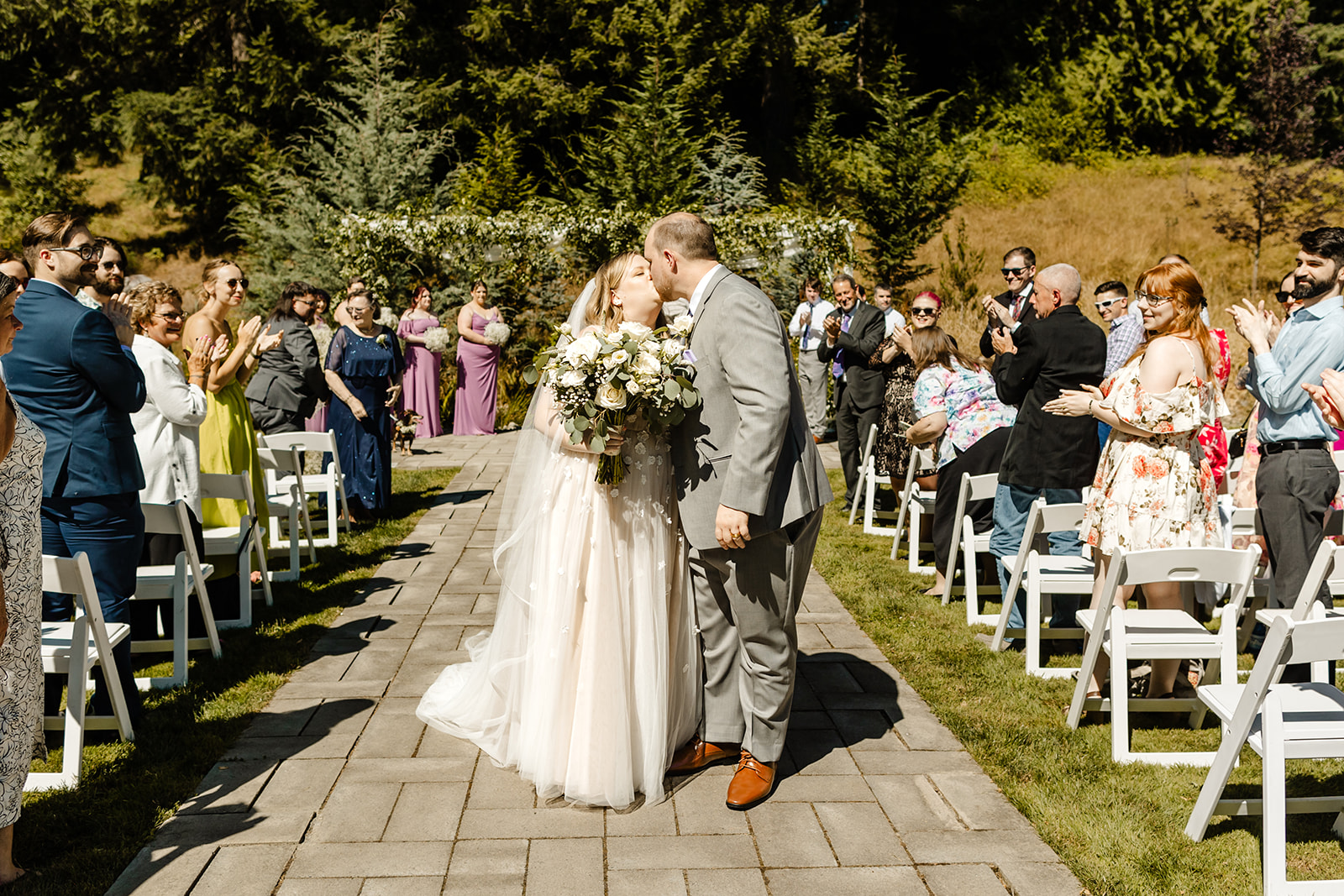 bride and groom kiss mid-aisle