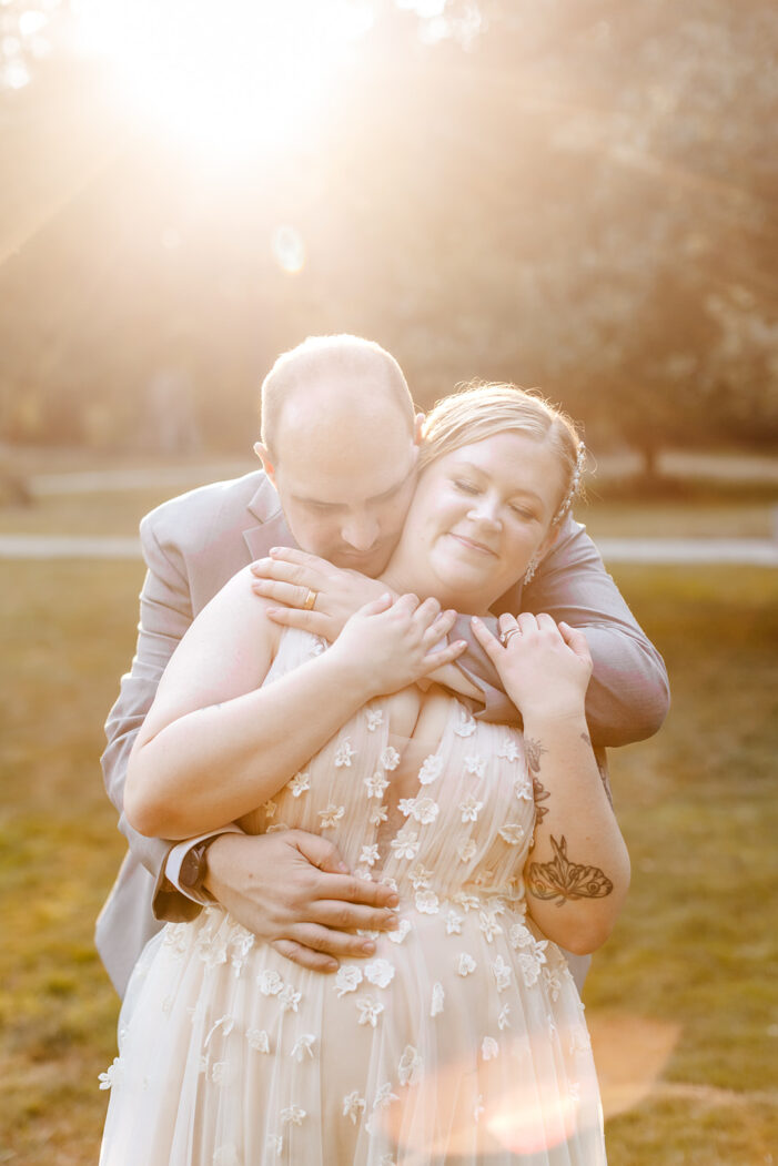 groom hugs bride from behind