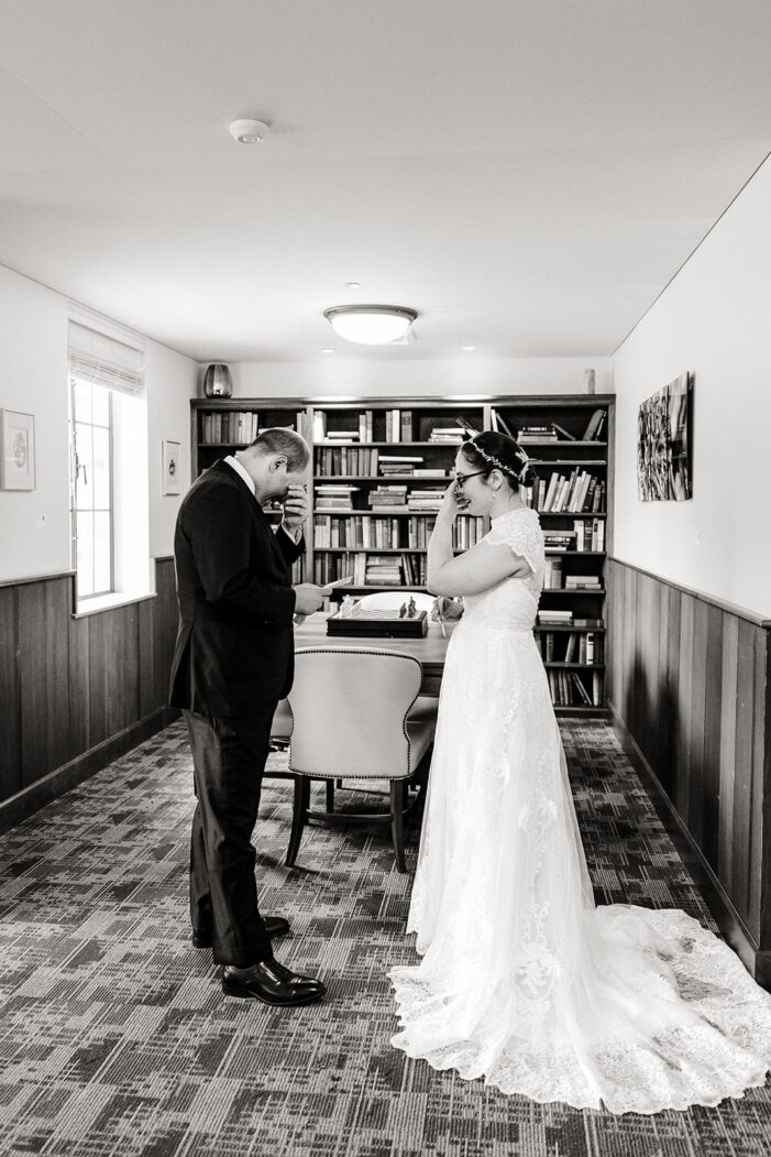 bride and groom read vows to each other in a library