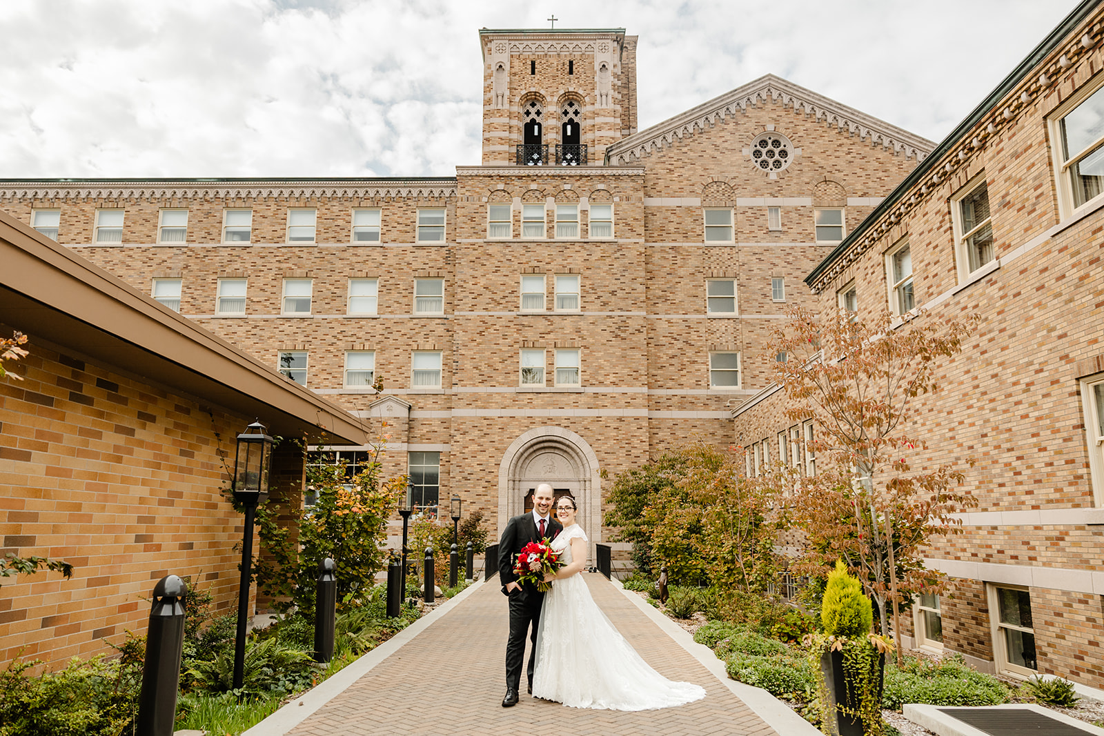 bride and groom embrace in front of lodge at st edwards