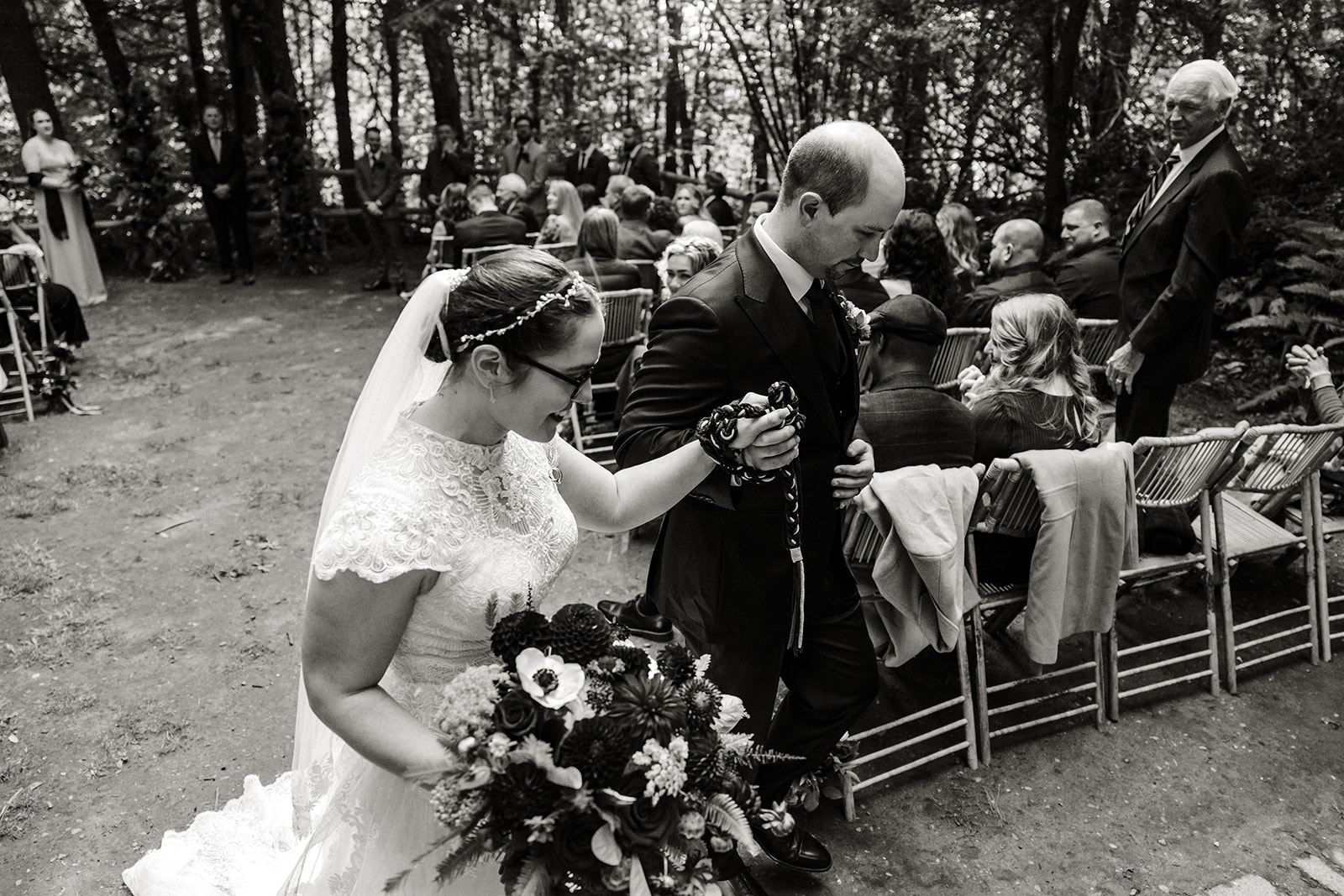 bride and groom walk out of ceremony hand in hand