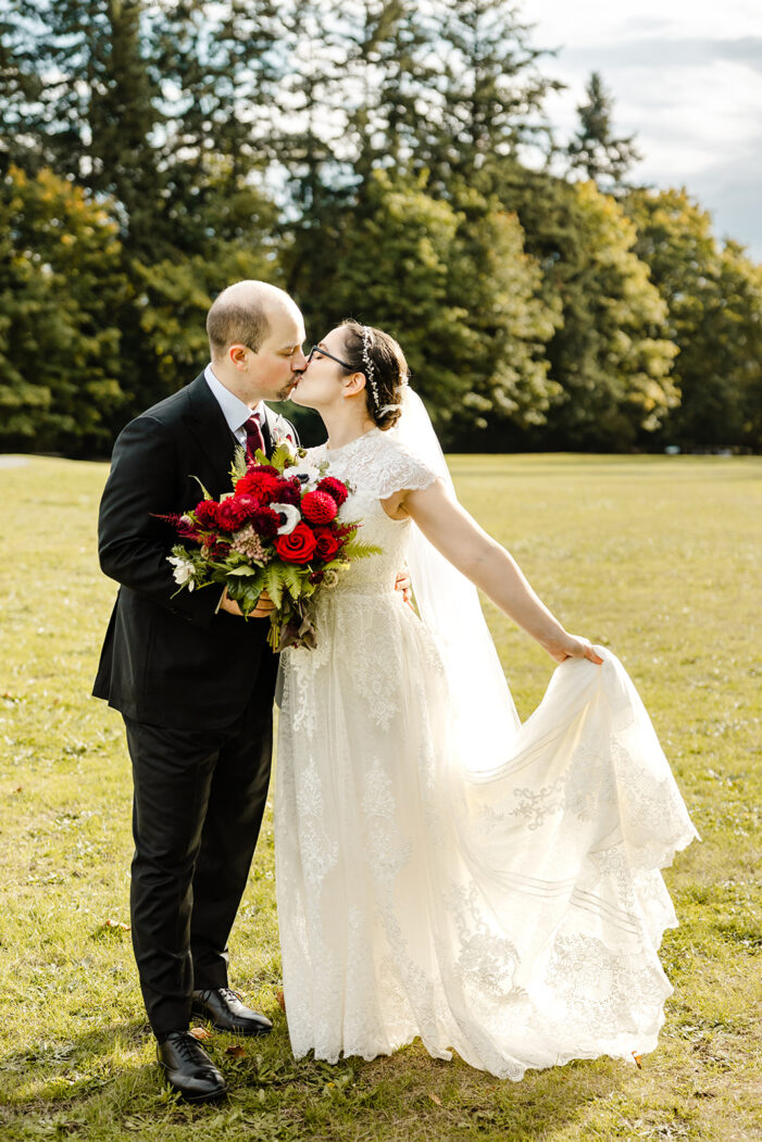 bride and groom kiss on a lawn