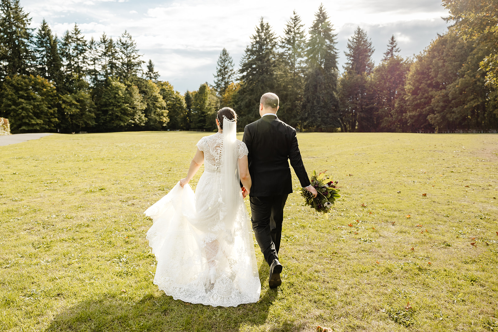 bride and groom walk across lawn