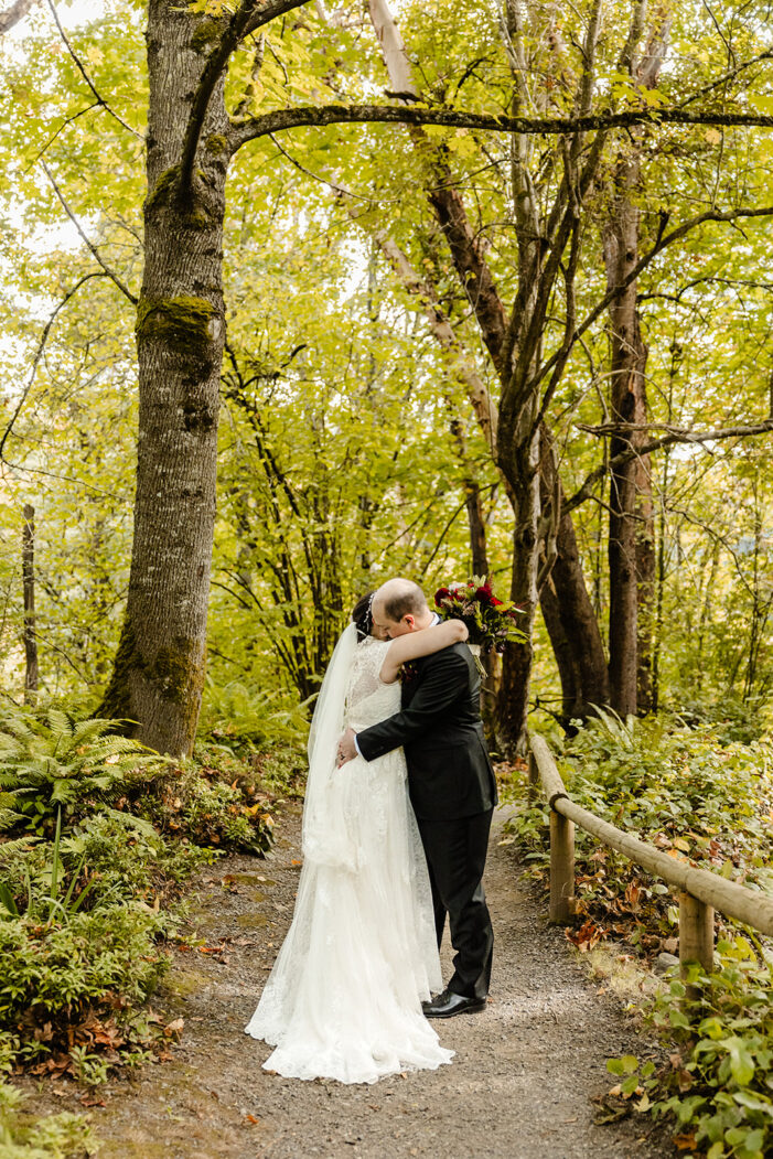 bride and groom kiss in the woods