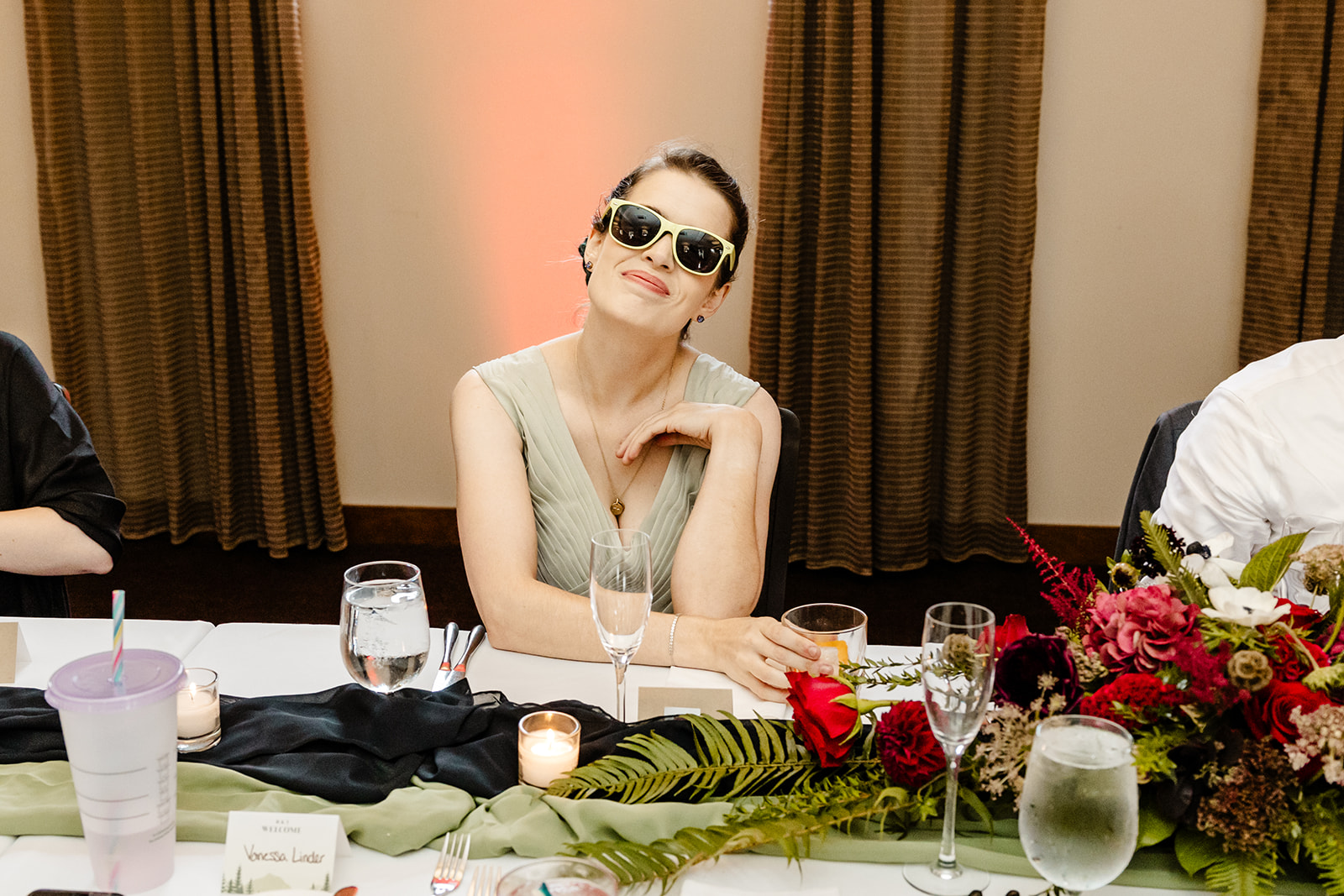 bride sits with sunglasses on at table