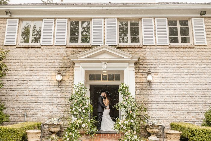 wedding rain plan ideas, indoor and outdoor wedding venue Lakewold Gardens couple standing in doorway of house sheltered from the rain