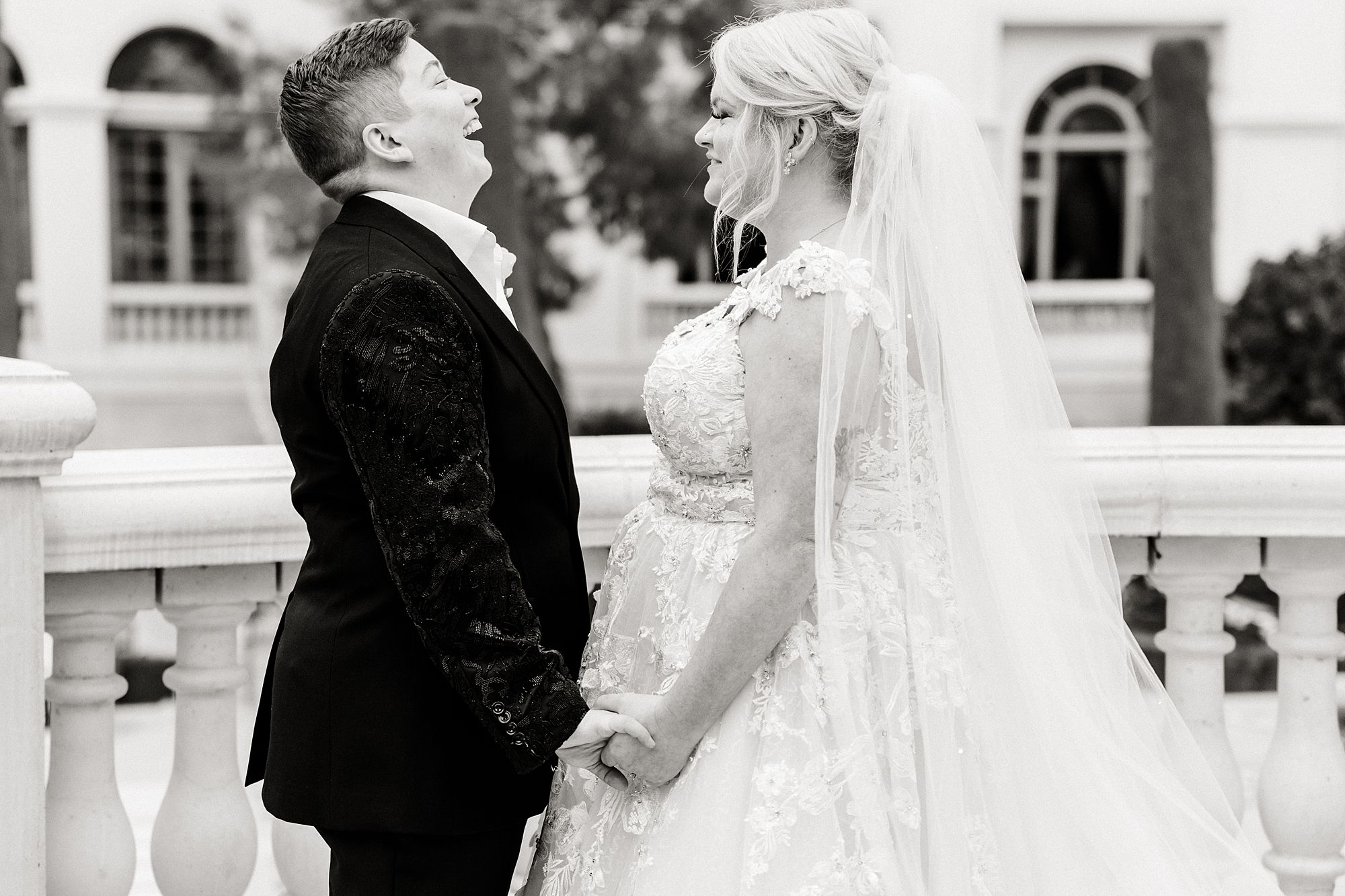 two brides holding hands laughing on wedding day