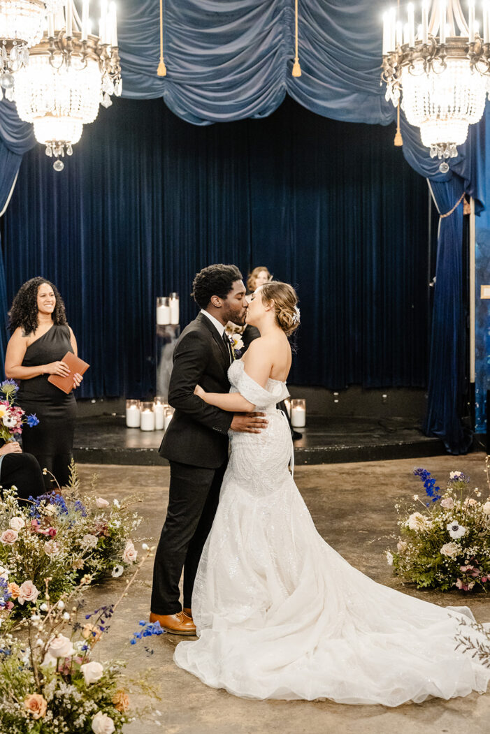 bride and groom kiss at ceremony