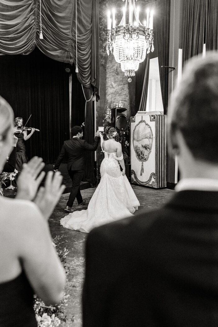 bride and groom walk away from ceremony at the ruins