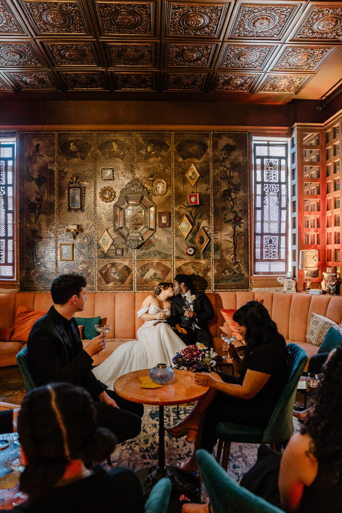 bride and groom cuddle on couch