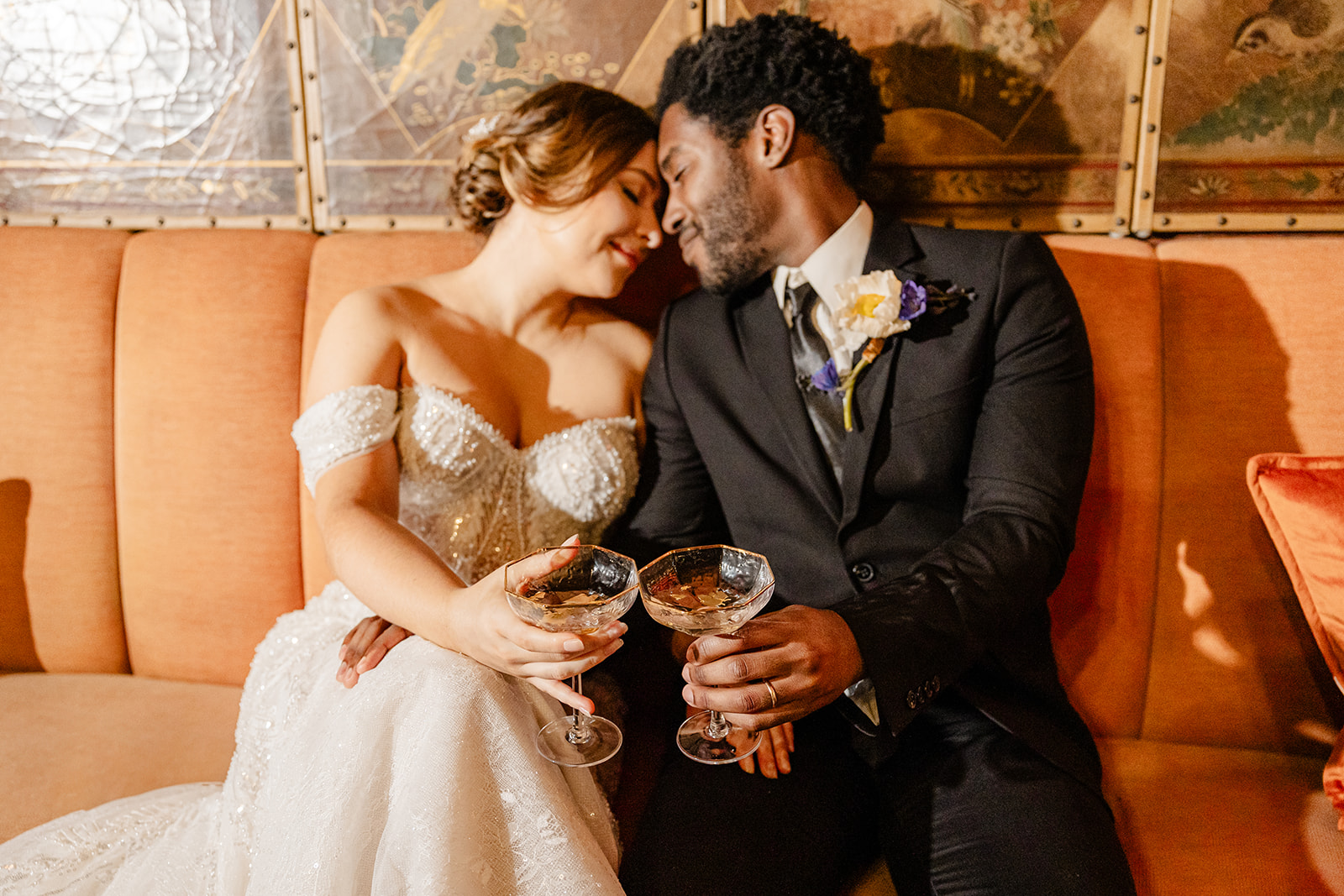 bride and groom cuddle on a couch together
