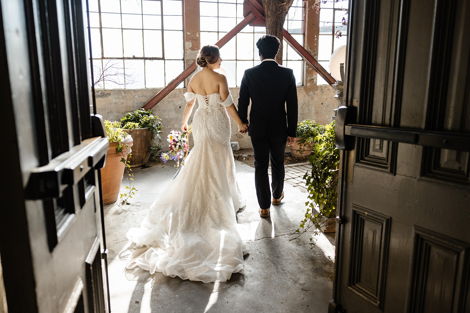 bride and groom walk through doors