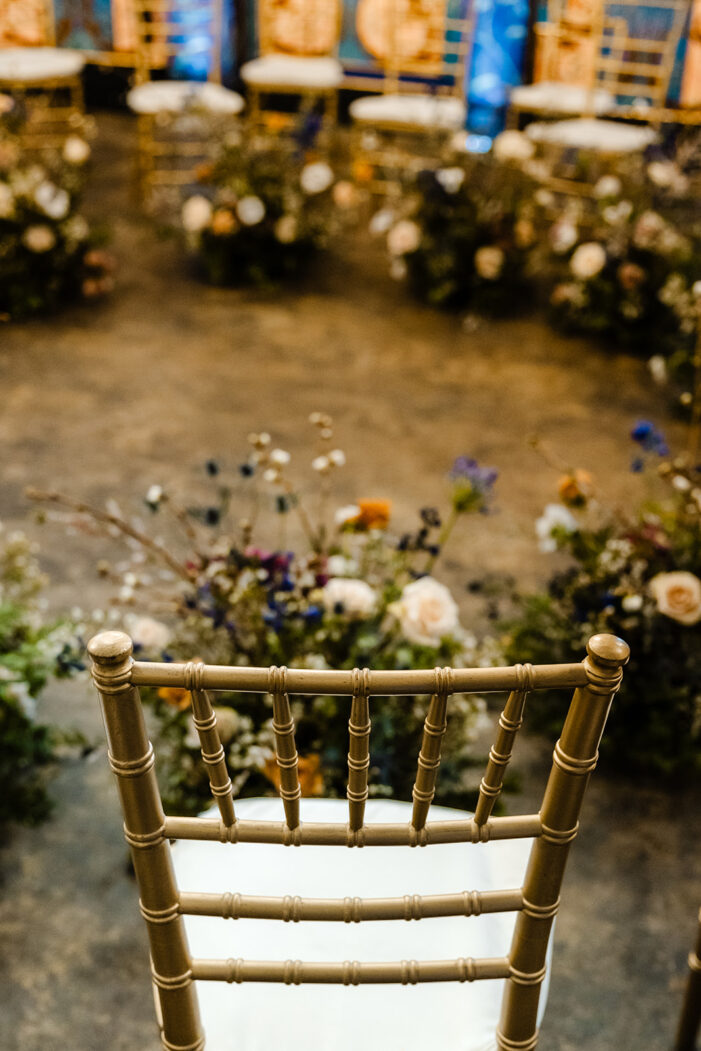 gold chair with florals in the background