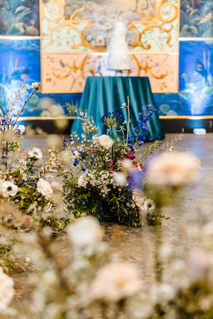 cake on a table with flowers in the foreground