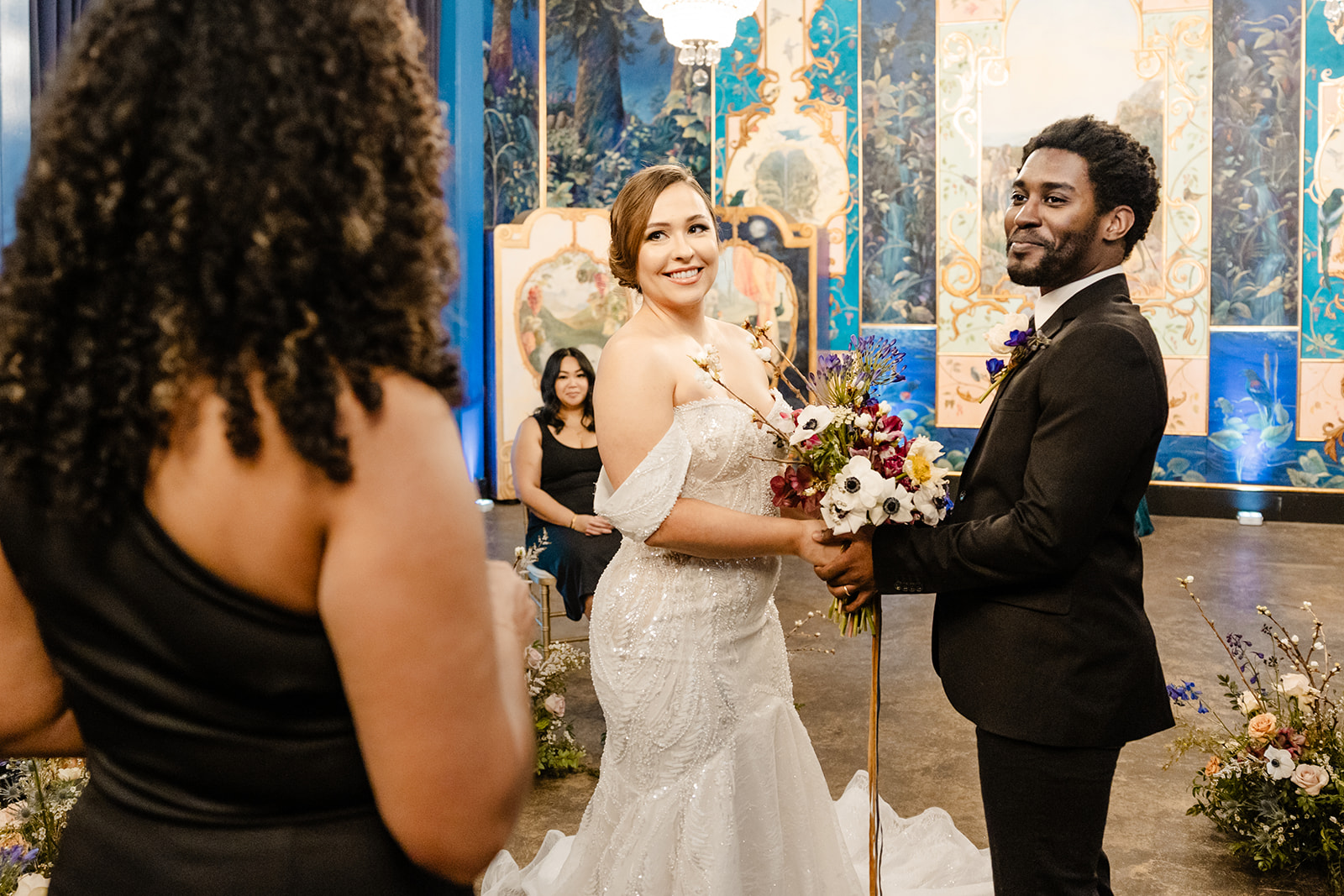 bride and groom stand at front of ceremony similng