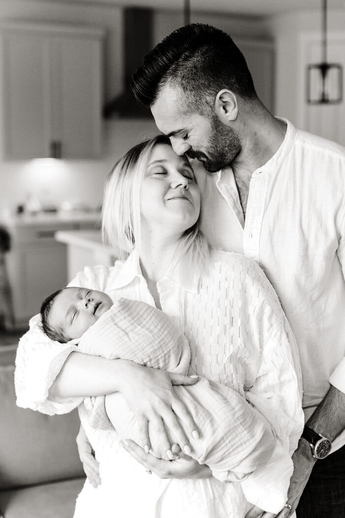 family snuggles with newborn