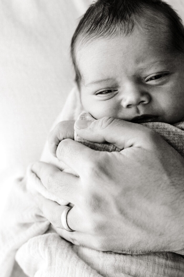 newborn wrapped in hand