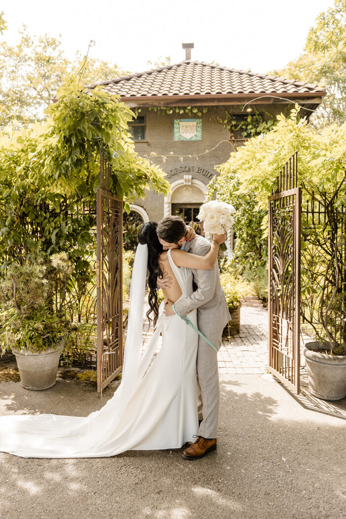 bride and groom embrace in front of corson building